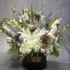 A sophisticated floral box arrangement combining soft whites, shimmering gold, and celebratory