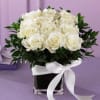  A short square vase arrangement of 12 snow-white roses with lush