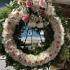 A beautiful white, pink, and green tribute wreath that calms This peaceful