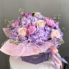 This dreamy arrangement combines lavender hydrangeas, soft blush roses, and rare pink