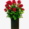 Classic two dozen roses combined with greenery in a modern ceramic vase.