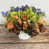 A bright, colorful display using seasonal blooms to represent a beautiful rainbow.