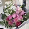 A hand-wrapped bouquet of stargazer lilies, variety of roses, stock and babies