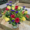 An airy arrangement of yellow and red roses with beautiful fillers to