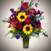 A vibrant, eye-catching floral arrangement featuring cheerful yellow sunflowers paired with rich