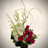 A striking modern floral arrangement featuring rich red roses paired with crisp