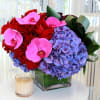 Vibrant jewel tones of magenta phalaenopsis orchids, purple hydrangeas, and deep red