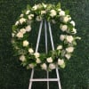 Stunning and quaint floral wreath designed with seasonal white flowers and greens.