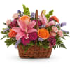 Like an island sunrise, this basket of orange and pink blooms are