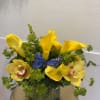 Bold yellow exotic florals arranged in a vase with dramatic foliage and