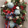 The Patriotic Standing Spray is a proud and meaningful tribute featuring hydrangea