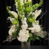 The arrangement includes Bells of Ireland, lime green spider mums, calla lilies