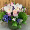 Hyacinths, tulips, roses and orchids in a cylinder vase. 
