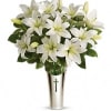 Fragrant white lilies in a glass vase inside a silver sleeve adorned