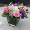 White hydrangeas, wax flower, spray roses, gumfrina, purple lisianthus, lemon leaf, and