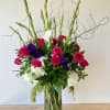 Beautiful round arrangement with a mixture of roses, orchids, hydrangeas, greenery, spray