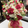Elegant floral arrangement featuring premium red and pink roses, white orchids, hydrangea