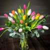 a beautiful assortment of 30 tulips is designed simply in a glass