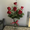 6 red roses arranged in glass vase w/ lg. silver heart pull