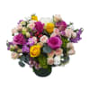 A lush round vase bursting with yellow, lavender, and pink -looks like