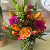 This vibrant flower arrangement bursts with the refreshing energy of citrus hues