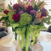 Assorted colorful seasonal blooms in a custom vase.