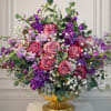 An elegant and romantic flower arrangement featuring soft mauve roses surrounded by