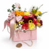 This charming floral arrangement features warm golden yellow blooms, soft blush flowers