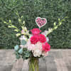 This lovely arrangement comes designed in a glass container with pink roses