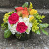 This arrangement has hydrangea, orange roses, yellow tulips, yellow alstroemeria, hot pink