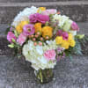 This arrangement has hydrangea, roses, spray roses, Carnations, lisianthus, hypericum, wax flower