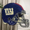 A giants helmet covered in flowers. This funeral piece is perfect for