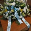 Sympathy with soft blue ribbon complimented by white carnations, lilies, mums and