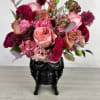 A bold and bewitching bouquet that fuses elegance with eerie charm. Nestled