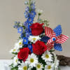 Flowers are arranged in an oversized Stars and Stripes coffee mug with