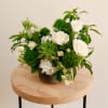 This flower arrangement features an artistic combination of delicate white blossoms such