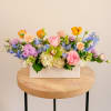 Bursting with spring color, this seasonal centerpiece features a cheerful mix of