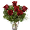 This arrangement has six roses, greens and a clear glass vase. If