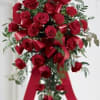 Red carnations and red roses are elegantly arranged and accented with a