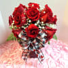 16 lush red roses atop a square red glass vase. Heart shaped