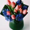A mix of tulips and fragrant hyacinths complemented with tropical leafs around