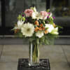 A tall bouquet of white gerberas, pink roses, alstromeria and assorted greenery