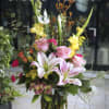 Tall arrangement of lilies, gladiolas, roses and assortment of  complimentary flowers.