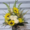 AN ALL AROUND ARRANGEMENT IN A 5X5 LEAF WRAPPED GLASS VASE. ARRANGEMENT