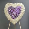 This elegant heart-shaped arrangement is a powerful expression of love, remembrance, and