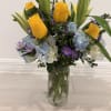bright and graceful floral arrangement featuring cheerful yellow roses, soft blue hydrangeas