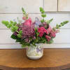 A lavender butterfly rests on medium pink roses, pink snapdragons, bells of