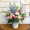 White lilies and pale pink roses, with blue delphinium, linnet cremon chrysanthemums