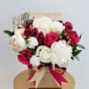 A lush arrangement of creamy white peonies, classic ivory roses, and vibrant
