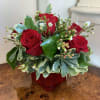 Half dozen red roses in a red cube glass vase and filler